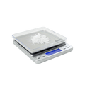 Digital kitchen scale with a small amount of white powder on a clear surface